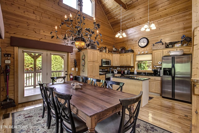 1551 Mountain Dreams Way, Sevierville, TN 37862 - dining area with high vaulted ceiling, wood walls, light wood-type flooring, and a notable chandelier