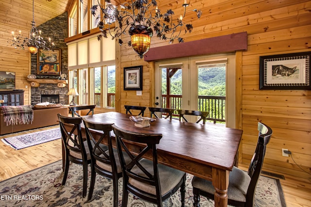 1551 Mountain Dreams Way, Sevierville, TN 37862 - dining area featuring wood-type flooring, wooden walls, high vaulted ceiling, and a healthy amount of sunlight