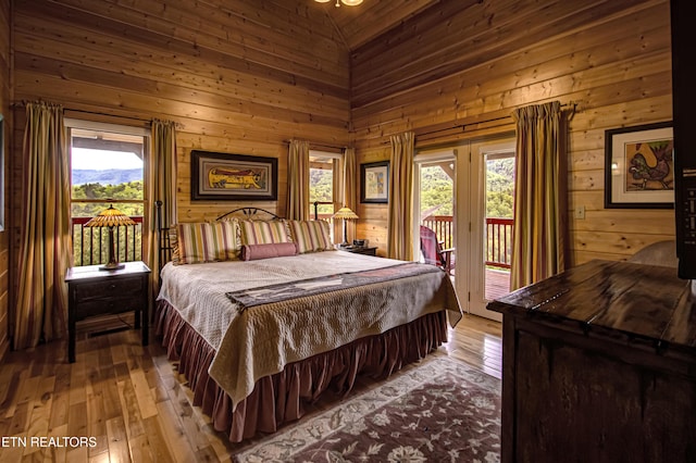1551 Mountain Dreams Way, Sevierville, TN 37862 - bedroom featuring wood walls, access to exterior, and light wood-type flooring