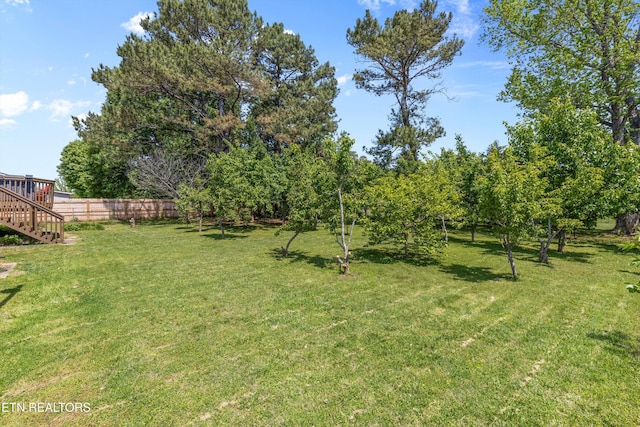 view of yard featuring stairway and fence