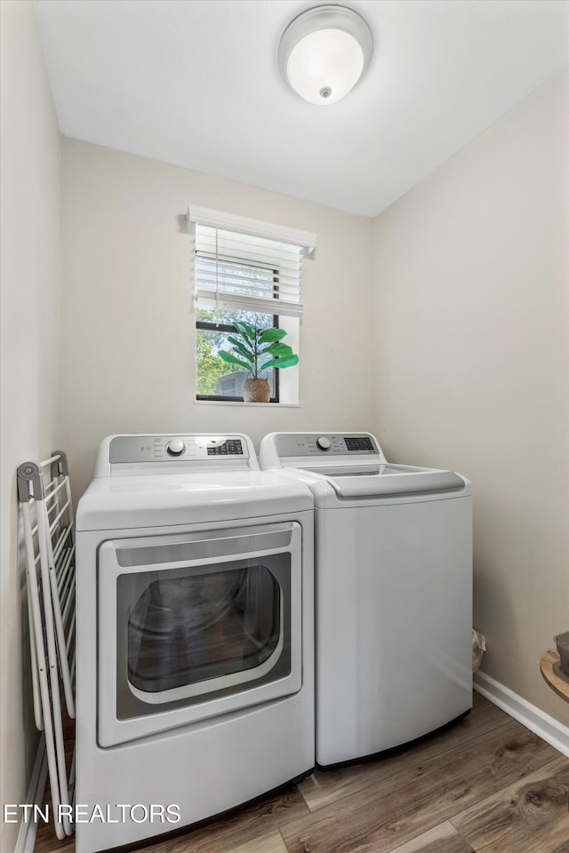 laundry room featuring separate washer and dryer, laundry area, and wood finished floors