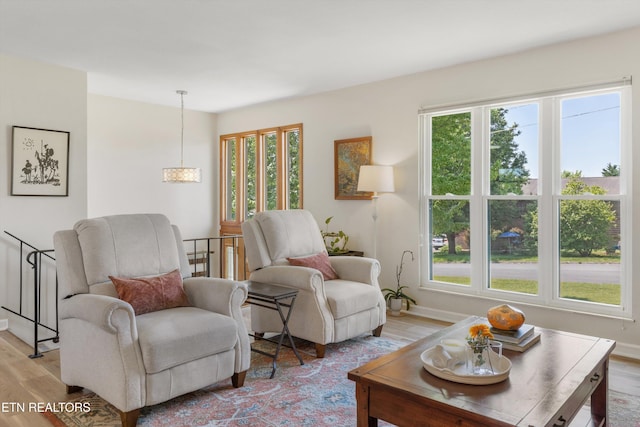 sitting room with light wood-style floors, baseboards, and plenty of natural light