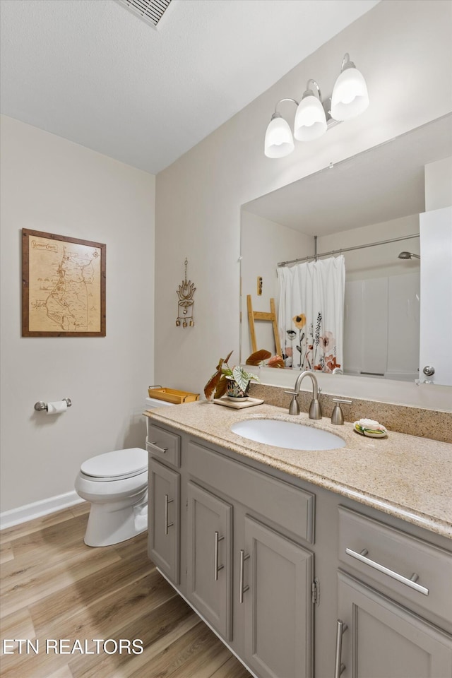 full bathroom featuring visible vents, curtained shower, wood finished floors, vanity, and toilet