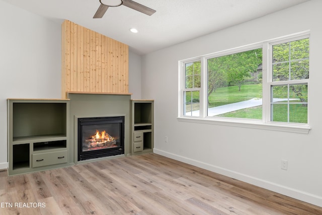 260 Yonside Dr, Sparta, TN 38583 - unfurnished living room with a glass covered fireplace, light wood-style flooring, a ceiling fan, baseboards, and recessed lighting