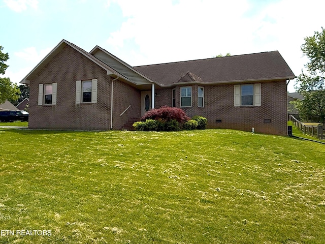 ranch-style home with a front yard, brick siding, and crawl space