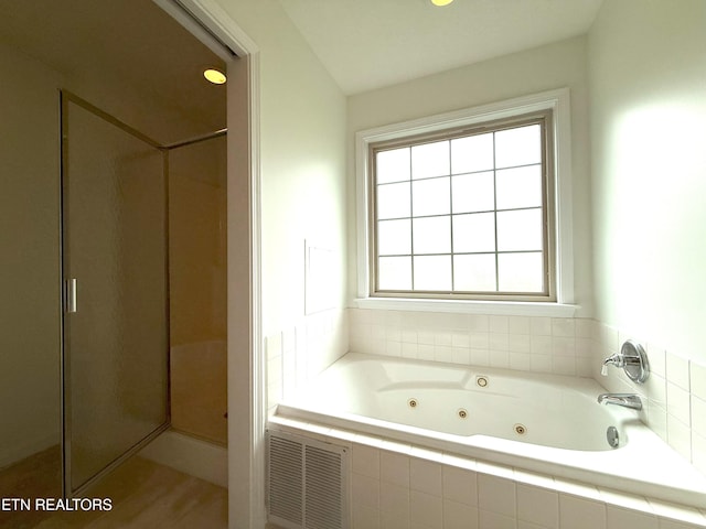 bathroom featuring visible vents, a whirlpool tub, and a stall shower