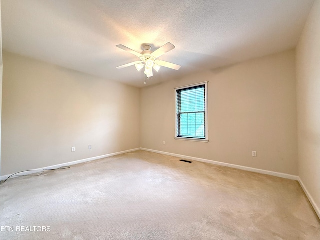 empty room with light carpet, baseboards, a ceiling fan, and visible vents