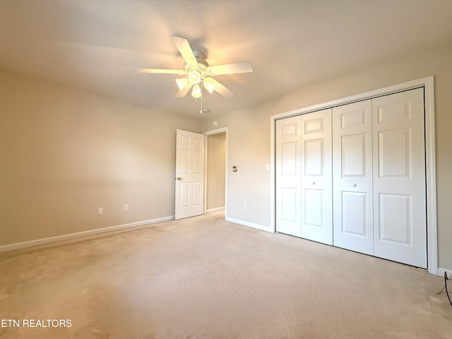 unfurnished bedroom with baseboards, light carpet, and a closet