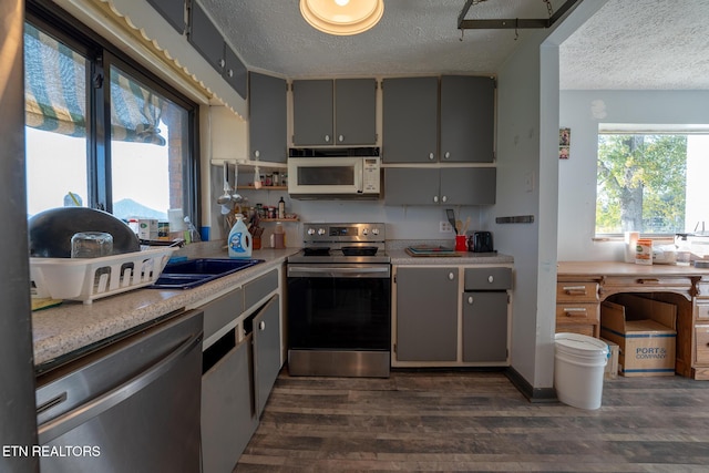 10724 E Emory Rd, Luttrell, TN 37779 - kitchen with stainless steel appliances, a textured ceiling, gray cabinetry, dark wood-style floors, and light countertops