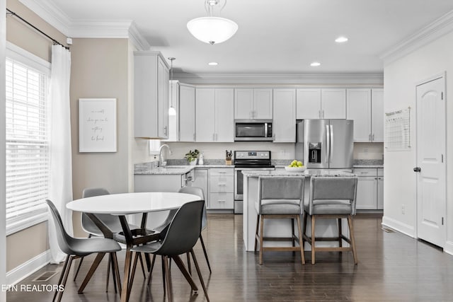 1724 Golden Nugget Ln, Knoxville, TN 37932 - kitchen featuring stainless steel appliances, a sink, baseboards, crown molding, and a breakfast bar area