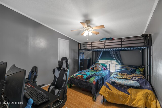 bedroom featuring ceiling fan, crown molding, vaulted ceiling, wood finished floors, and baseboards