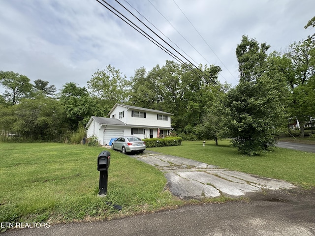 view of front of home featuring an attached garage, a front lawn, and driveway