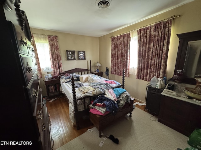 bedroom featuring visible vents and hardwood / wood-style flooring