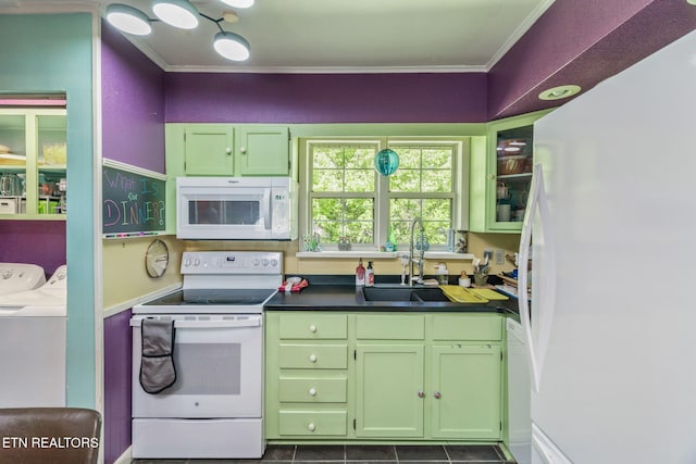 kitchen featuring white appliances, green cabinetry, a sink, crown molding, and washing machine and clothes dryer
