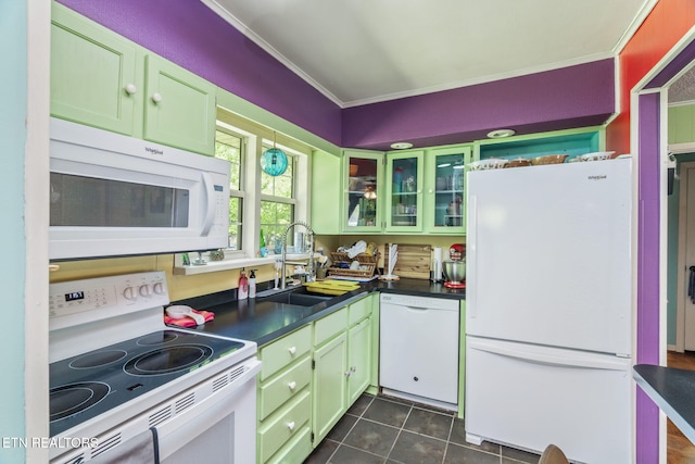 kitchen featuring ornamental molding, white appliances, a sink, dark tile patterned floors, and dark countertops