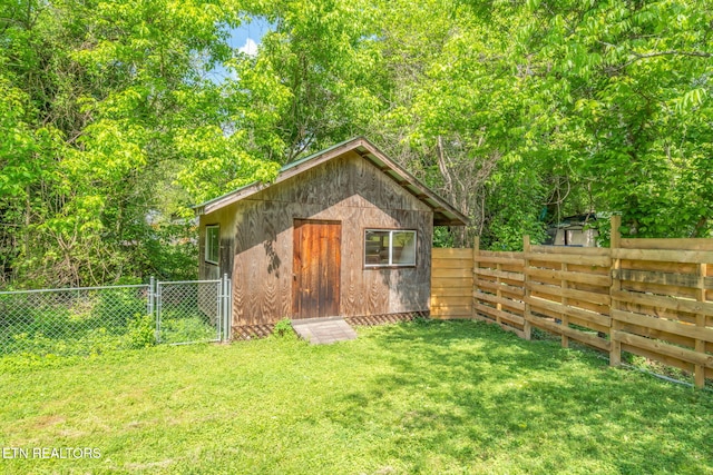 view of outbuilding with a fenced backyard and a gate