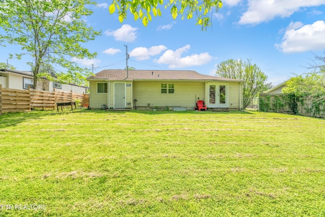 back of house with french doors, a lawn, and a fenced backyard