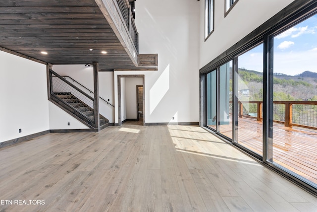 3540 Mountain Tyme Way, Sevierville, TN 37862 - unfurnished living room featuring a mountain view, wood finished floors, baseboards, and stairs