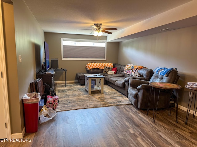 living room with baseboards, a ceiling fan, and wood finished floors