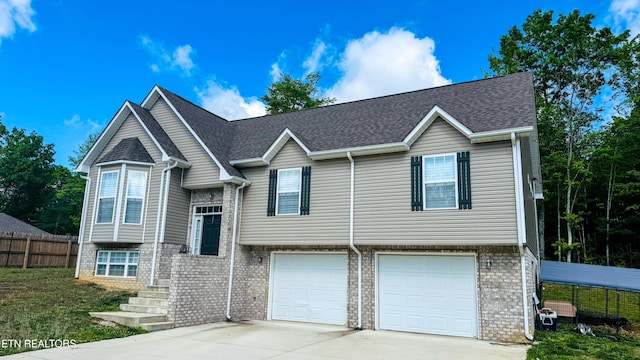 344 Kayla Ln, Oneida, TN 37841 - bi-level home with concrete driveway, an attached garage, fence, and brick siding