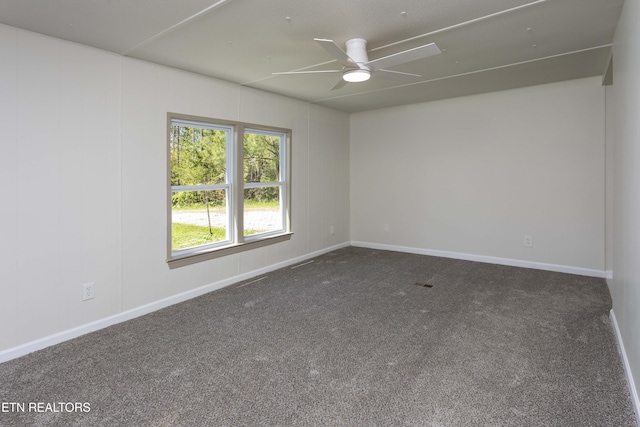 carpeted spare room with baseboards and a ceiling fan