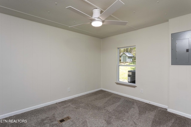 unfurnished room with visible vents, carpet floors, baseboards, ceiling fan, and electric panel