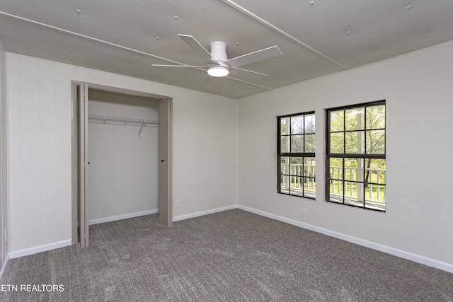 unfurnished bedroom with carpet floors, baseboards, ceiling fan, and a closet