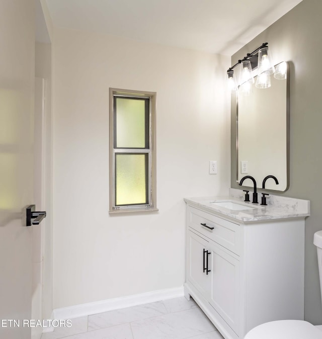 bathroom with baseboards, marble finish floor, toilet, and vanity