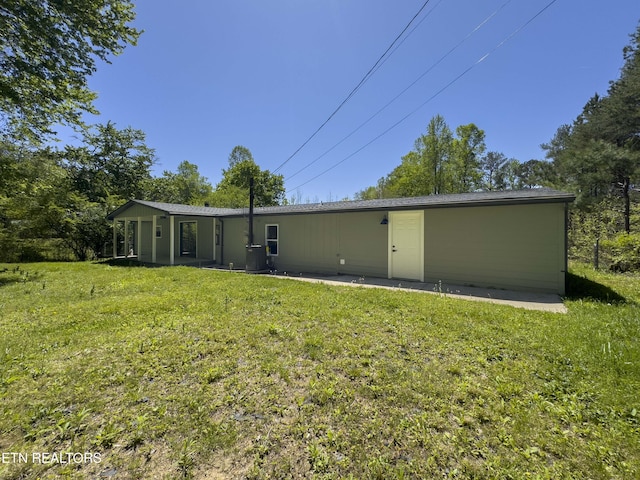 back of house with a yard and central AC