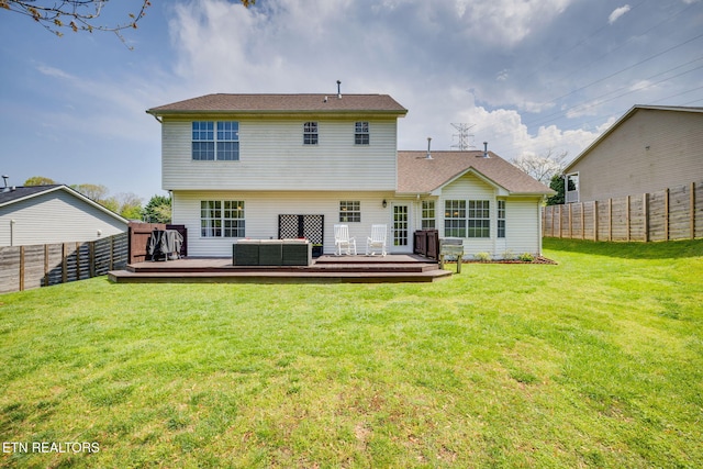 back of house with a wooden deck, a lawn, and a fenced backyard