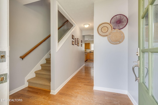 hallway featuring baseboards and light wood-type flooring