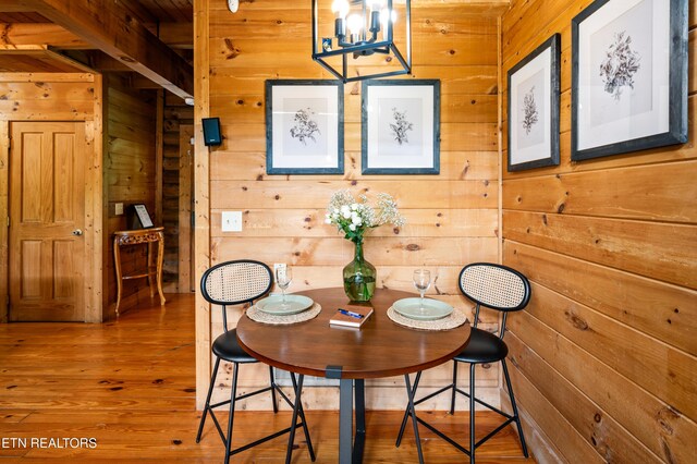 dining area with wood finished floors and wooden walls