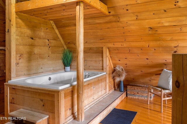 interior space featuring wooden ceiling, wood finished floors, and a bath