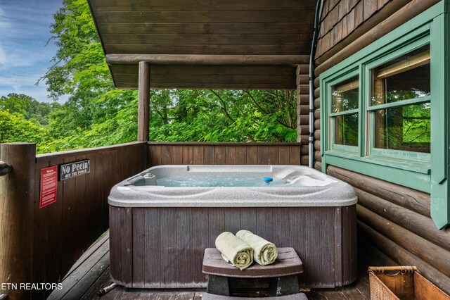 wooden terrace featuring a hot tub