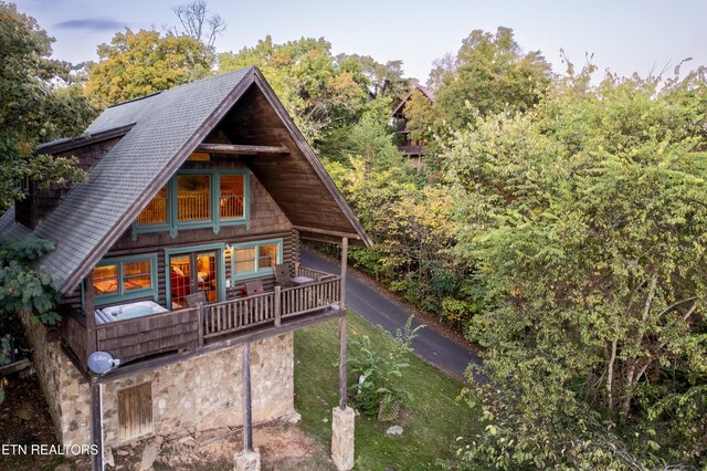 exterior space featuring a lawn and a shingled roof