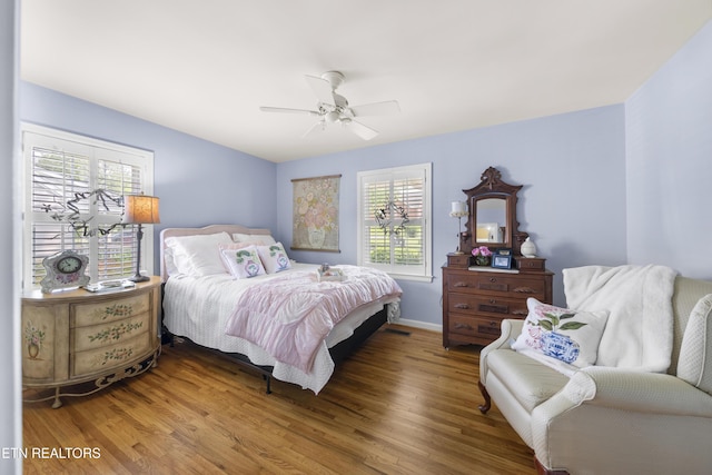 bedroom with baseboards, ceiling fan, and wood finished floors