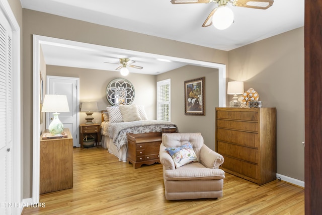 bedroom with ceiling fan, baseboards, and light wood-type flooring