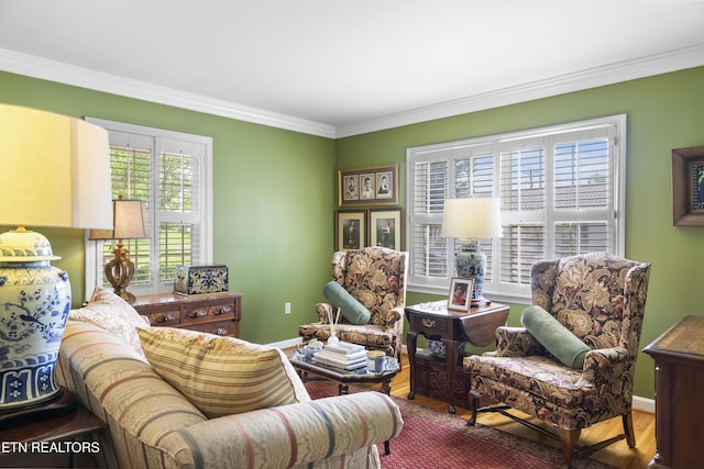 living area featuring crown molding, baseboards, and wood finished floors