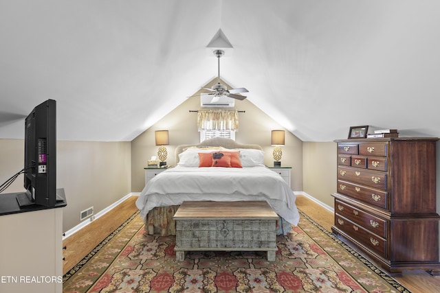 bedroom featuring visible vents, baseboards, wood finished floors, and vaulted ceiling