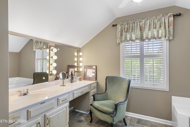 bathroom featuring baseboards, plenty of natural light, vaulted ceiling, and a garden tub