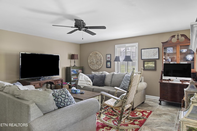 living room with baseboards and ceiling fan