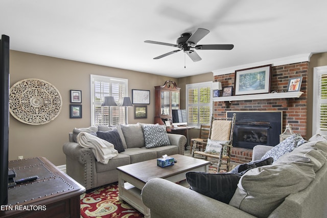 living area featuring plenty of natural light, ceiling fan, and a fireplace