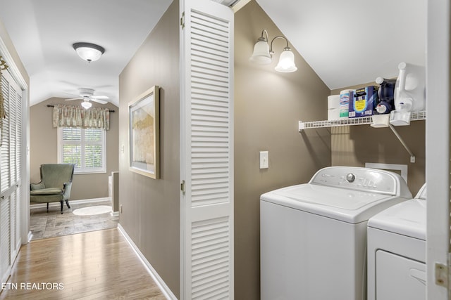 washroom with laundry area, washing machine and dryer, baseboards, light wood-style floors, and ceiling fan