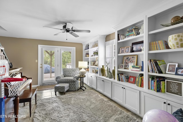 sitting room with a ceiling fan, tile patterned floors, and built in features