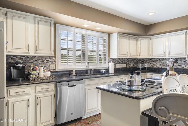 kitchen featuring dark stone counters, tasteful backsplash, a sink, and dishwasher