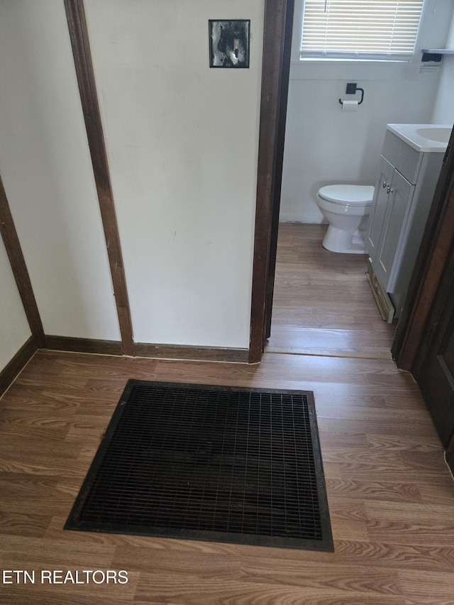 bathroom featuring toilet, visible vents, wood finished floors, and vanity