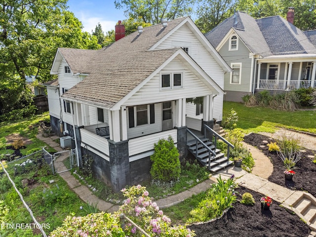 view of front of property featuring a porch, fence, a chimney, and a gate
