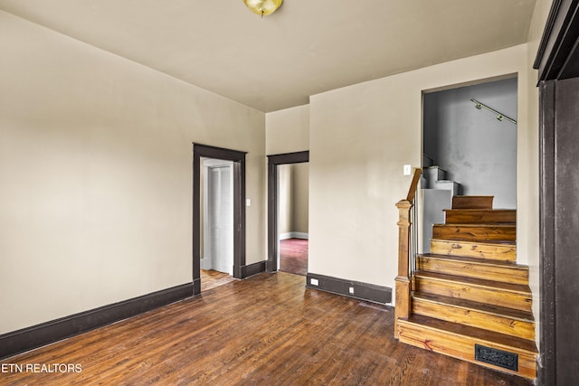 unfurnished room featuring stairway, baseboards, and wood finished floors