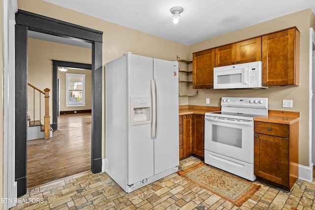 kitchen with open shelves, brown cabinets, light countertops, baseboards, and white appliances