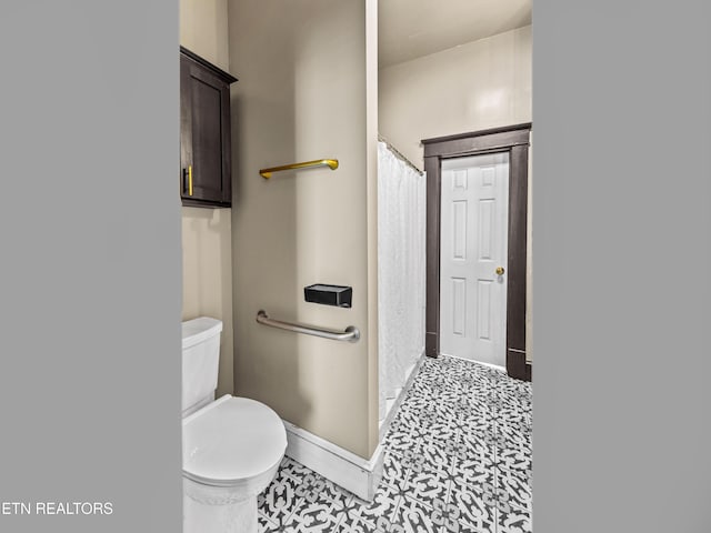 bathroom with baseboards, tile patterned floors, curtained shower, and toilet